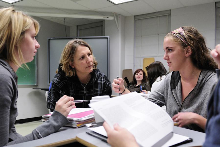 Terry Koenig works with seated students in a classroom setting.